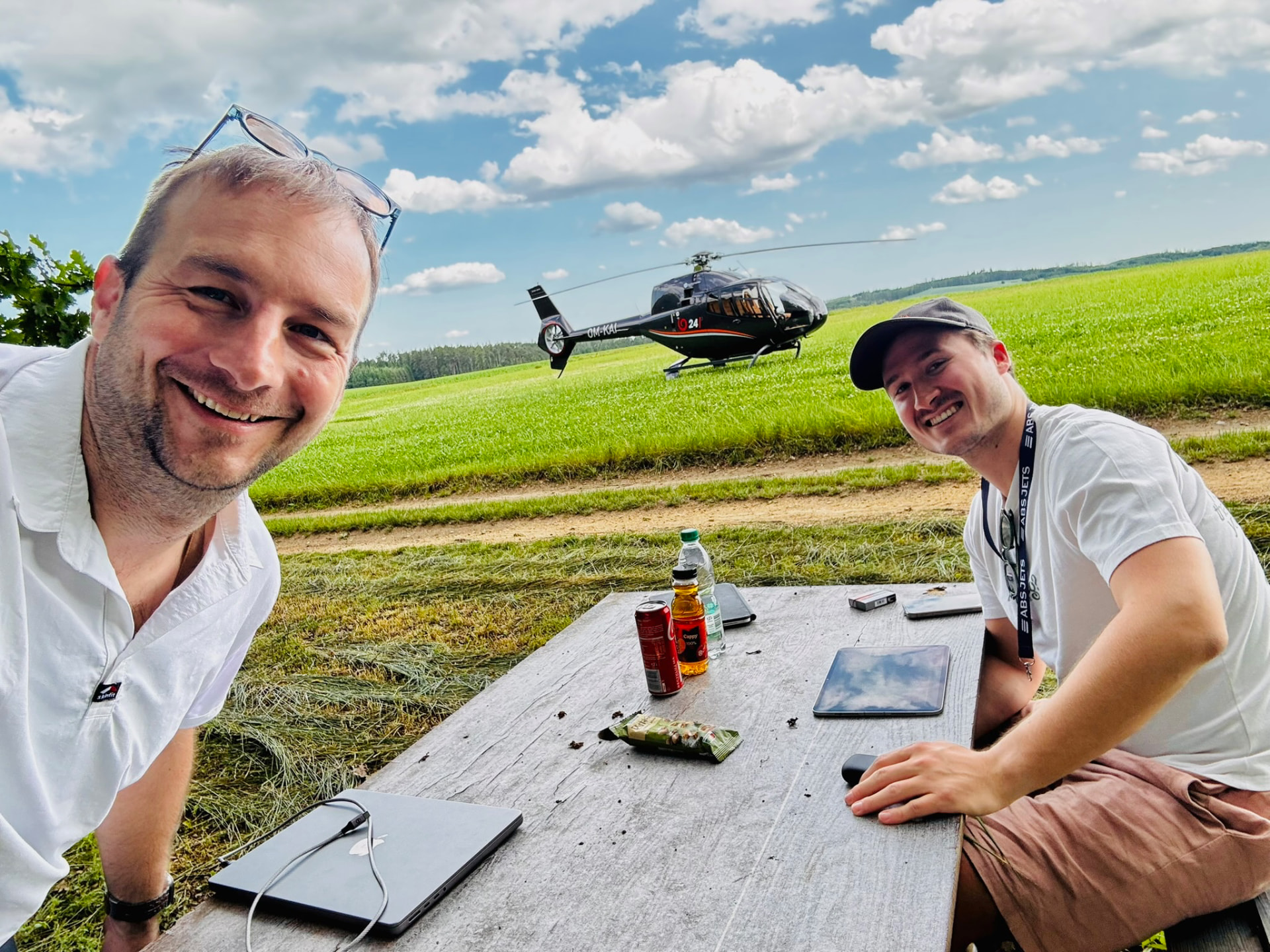 EC120 Colibri on an airfield meadow with two pilots
