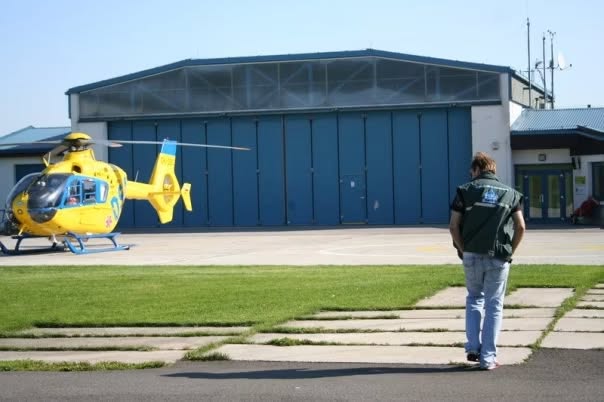 Jan Krčil na letišti před hangárem s vrtulníkem EC135