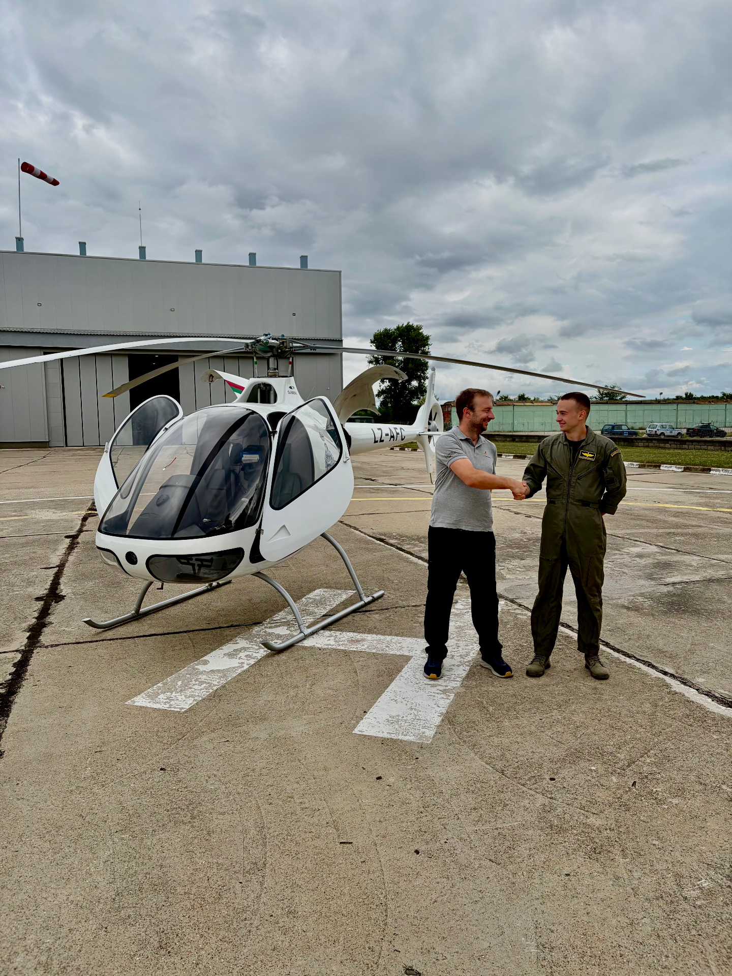 Félicitations à un élève après la réussite de son examen devant un hélicoptère Guimbal Cabri G2 à Pleven