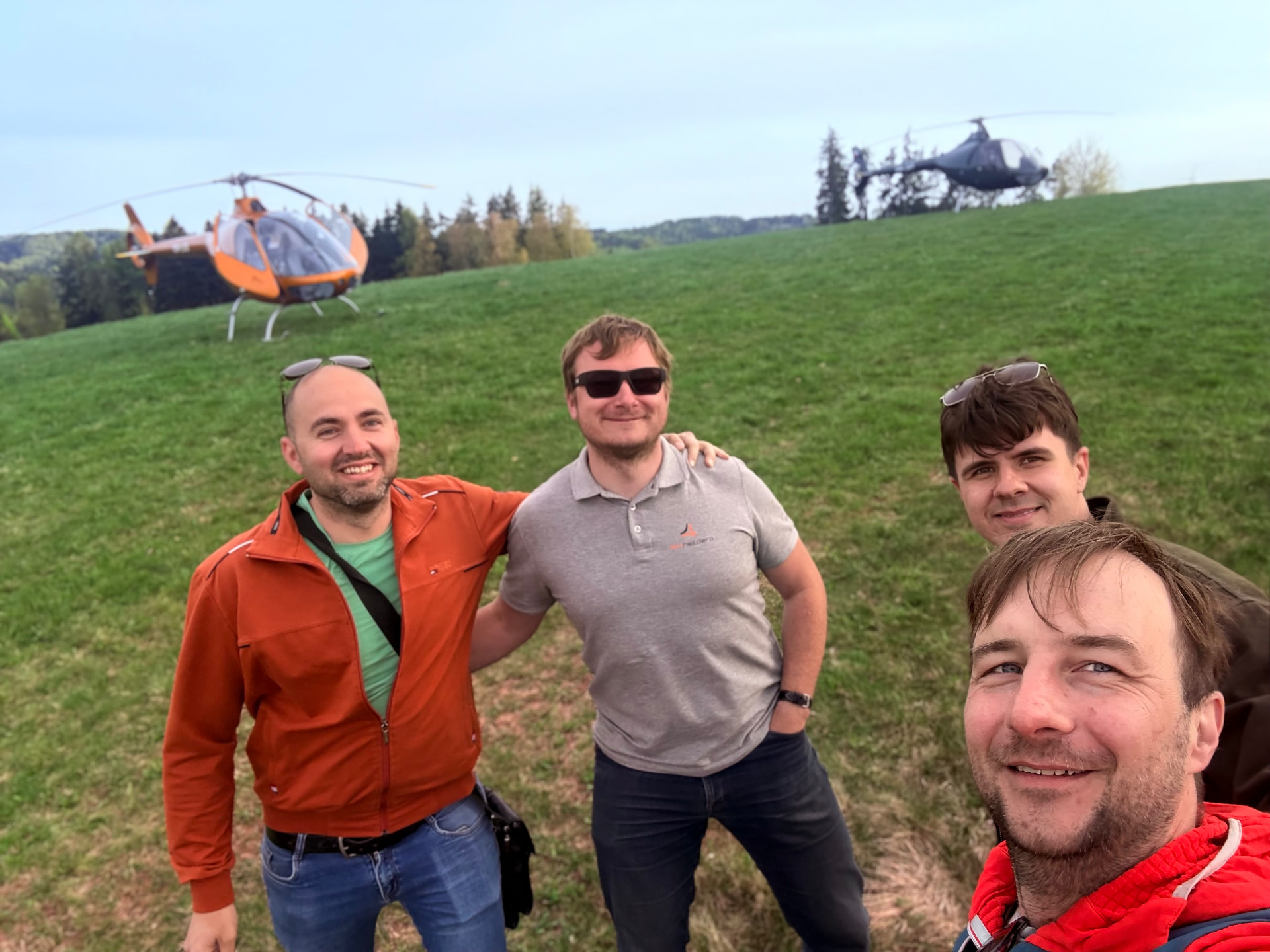 Piloti u vrtulníků na louce po výcvikovém letu
